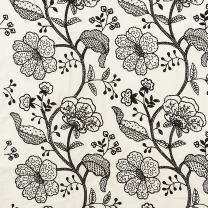 Cream fabric with an intricate black floral pattern of twisting vines and large blossoms.