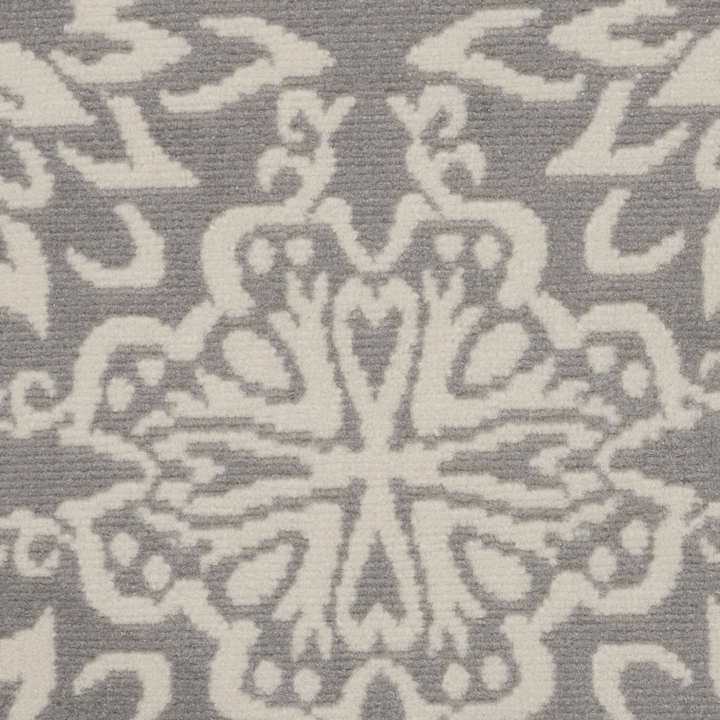 Gray and white damask textile with a central floral snowflake-like medallion, close-up.