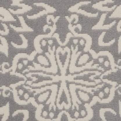 Gray and white damask textile with a central floral snowflake-like medallion, close-up.