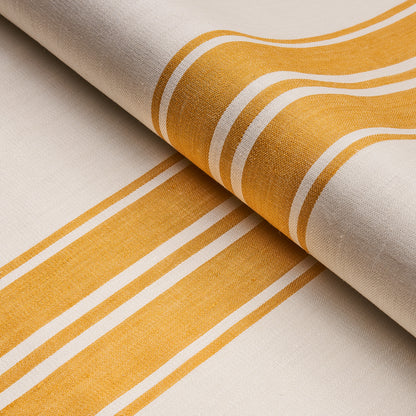 Beige woven fabric with bold yellow and white stripes, rolled textile for home decor or table linens.