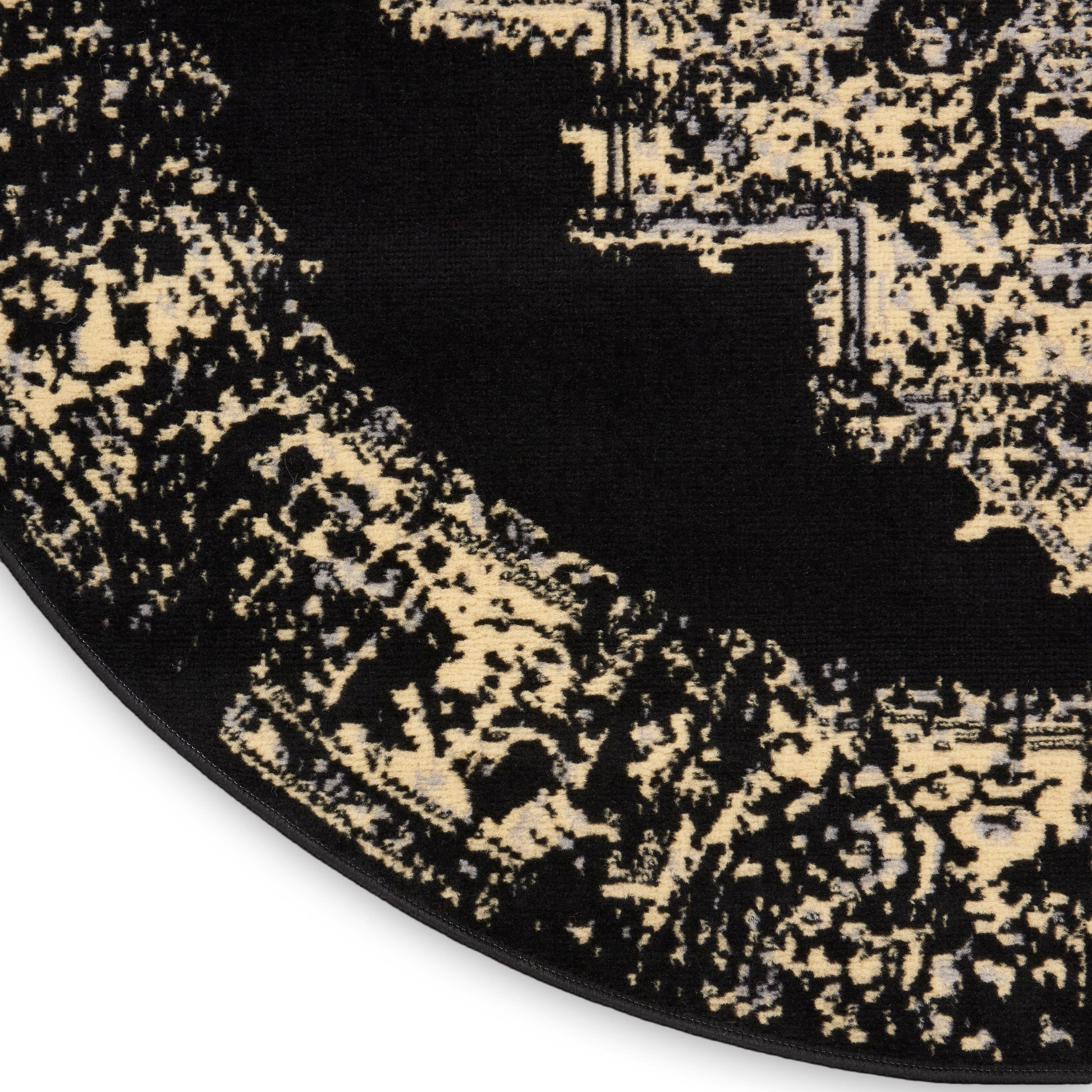 Round rug with black & beige abstract pattern, plush textured pile, bound edge.