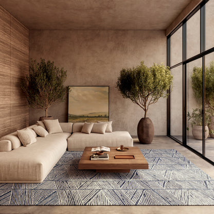 Beige modular sofa with cushions, wooden coffee table, blue geometric rug, potted trees, modern living room