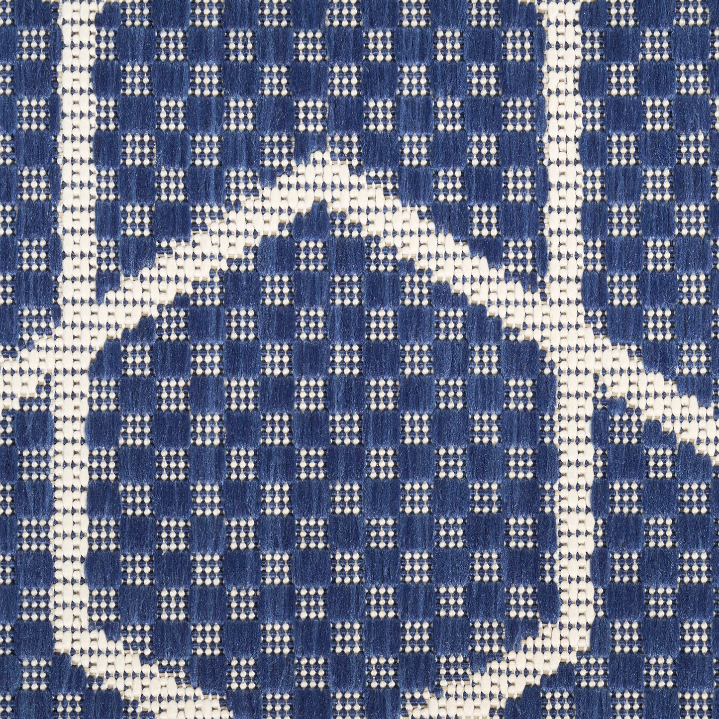 Close-up of blue and white woven fabric with diamond lattice pattern and dotted accents.