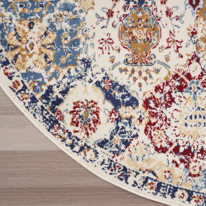 Round Persian-style area rug with cream background, blue, gold & red motifs, bound edge on wood floor.