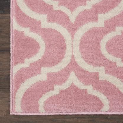 Pink and white trellis-pattern rug with plush texture on dark wood floor.