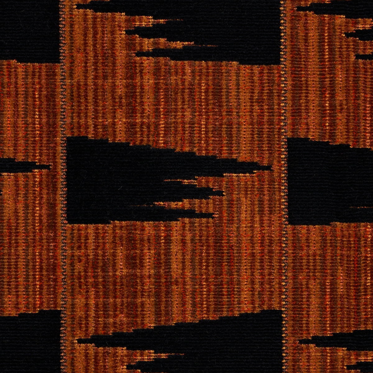 Woven rug with orange-brown and black geometric blocks in a bold abstract pattern.