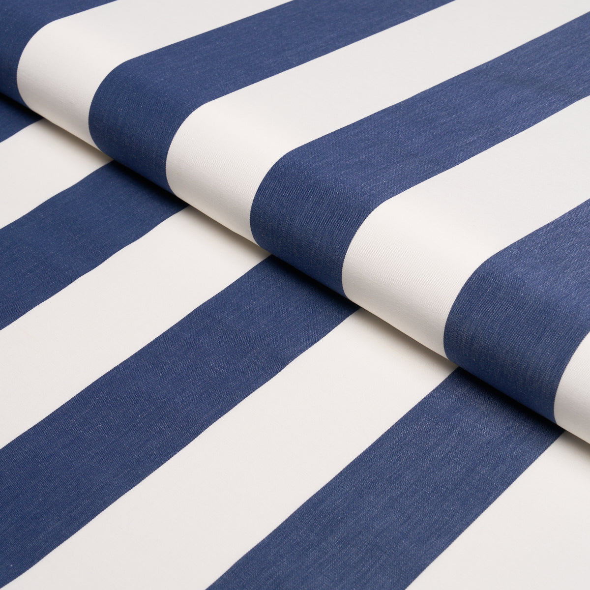 Navy blue and white striped fabric, folded on a roll; bold wide stripes, woven textile for upholstery or home decor.