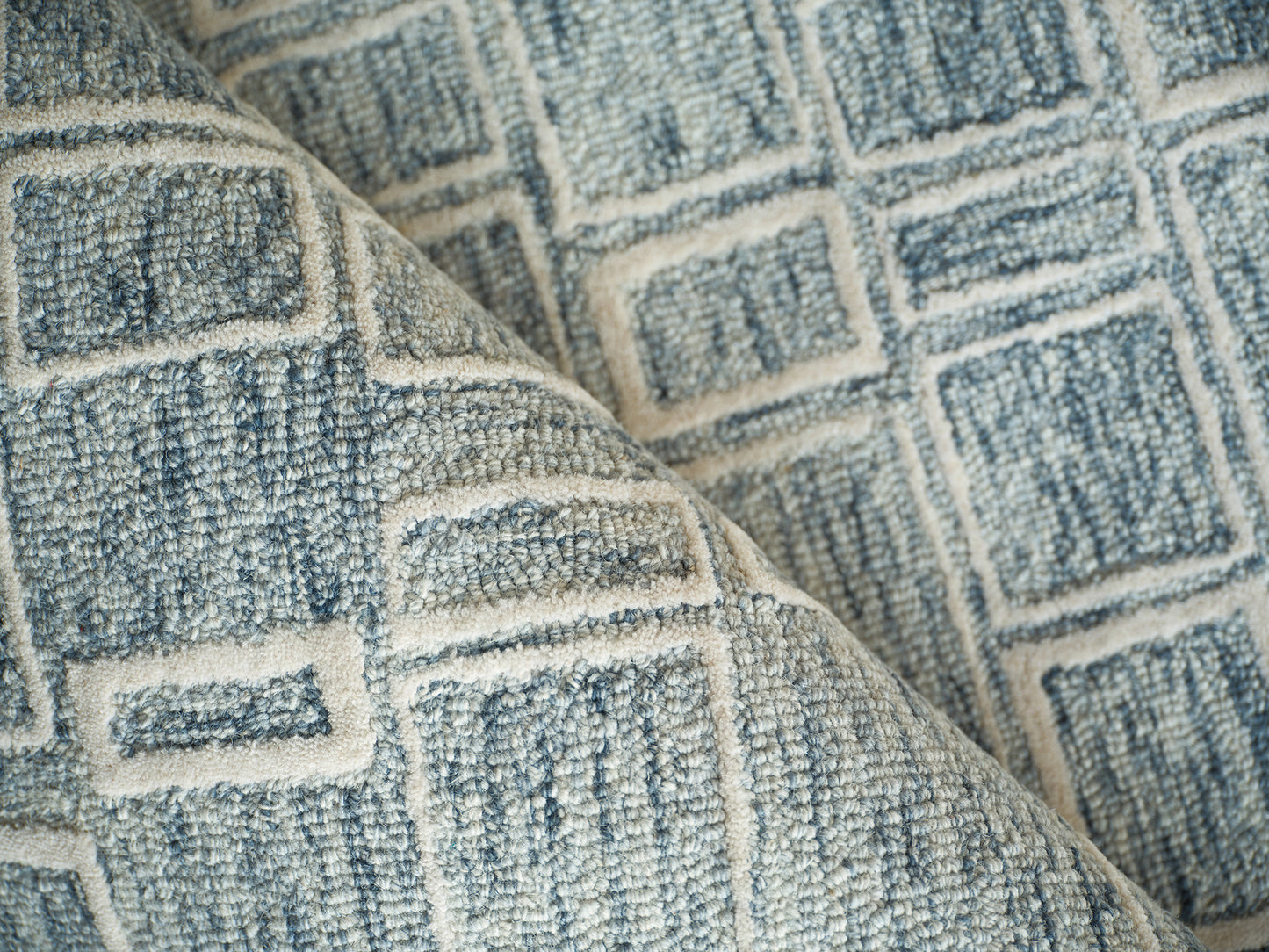 Blue and ivory geometric woven rug with square pattern and textured fabric.