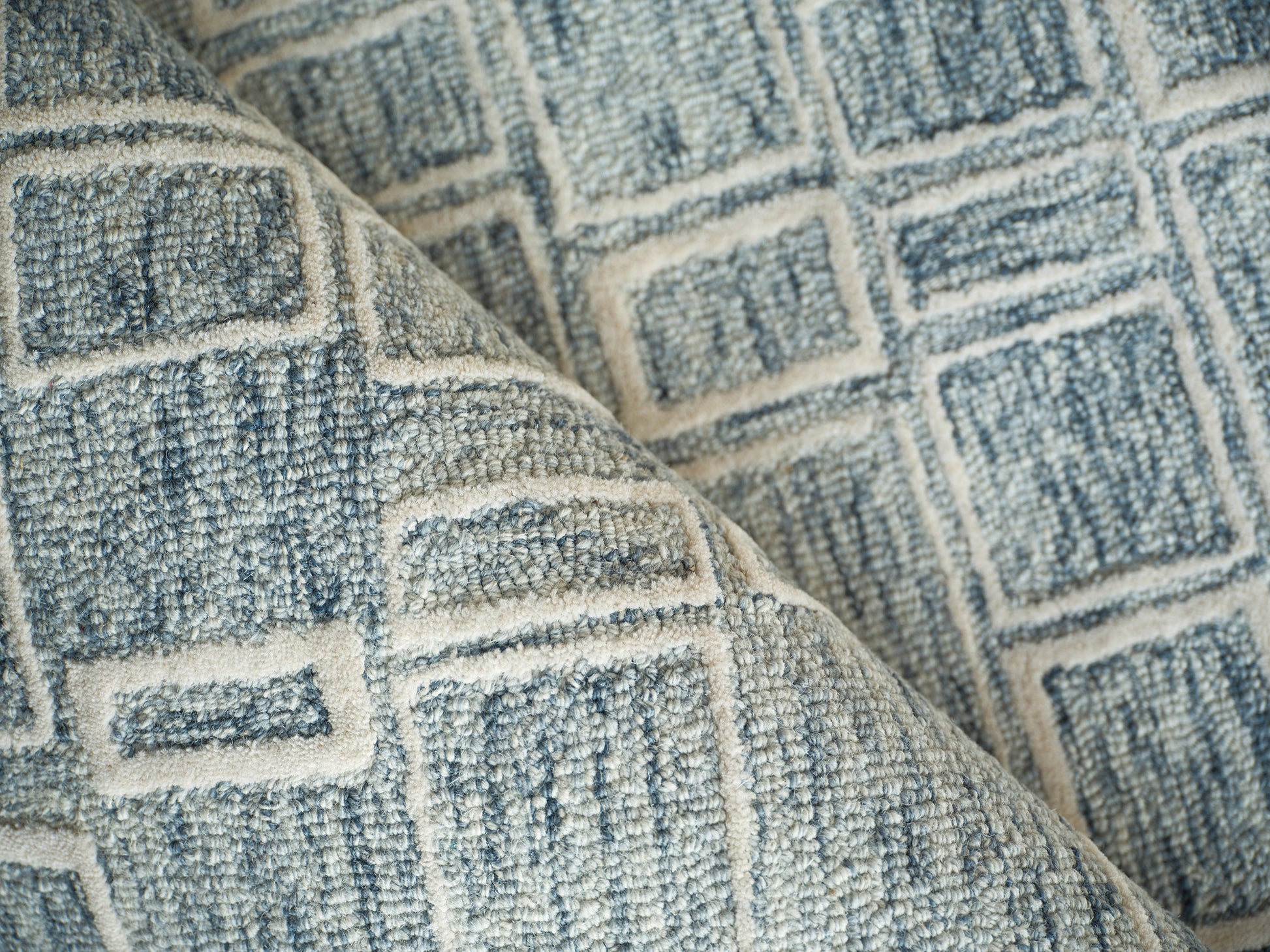 Blue and ivory geometric woven rug with square pattern and textured fabric.