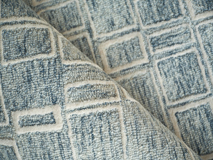 Blue and ivory geometric woven rug with square pattern and textured fabric.