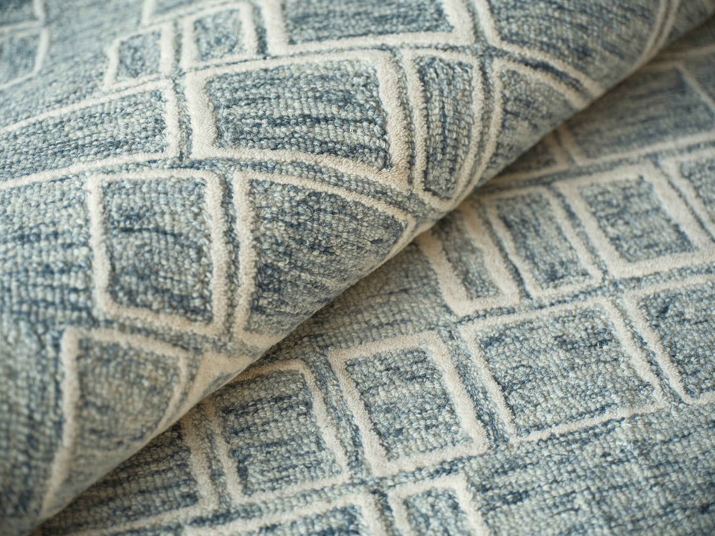 Blue-gray indoor hand-tufted rug with a white square-grid pattern; soft fabric.