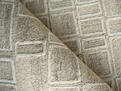 Beige tufted rug with square grid pattern, plush texture, folded corner.
