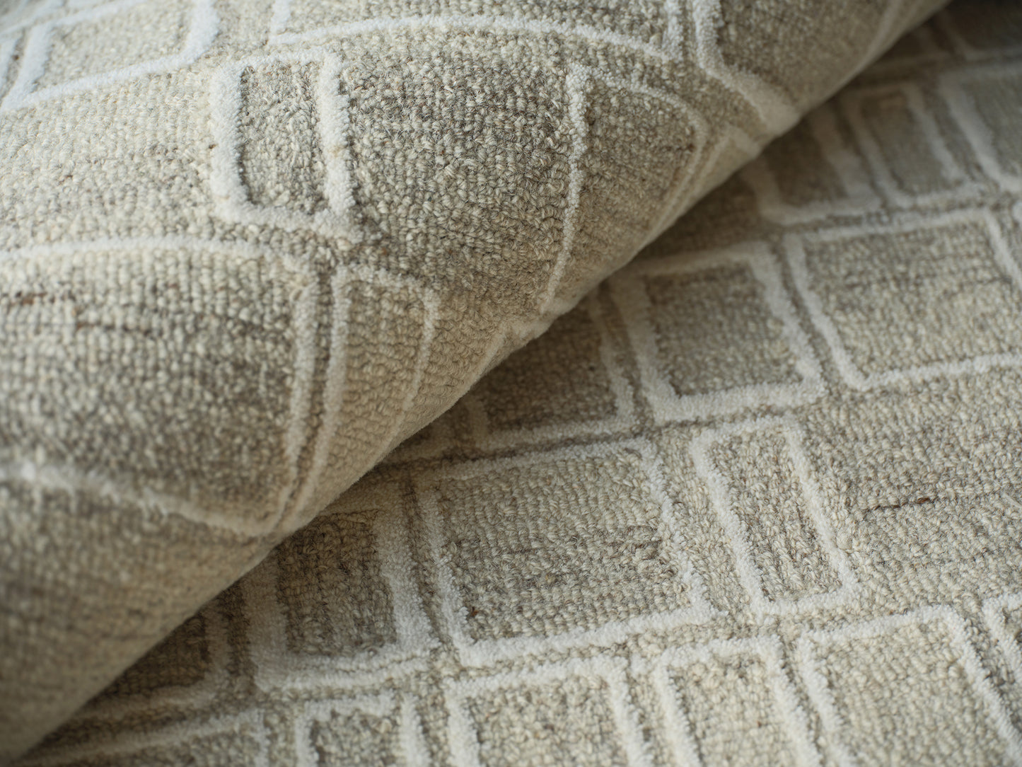 Beige rug with raised square geometric pattern and soft looped pile.