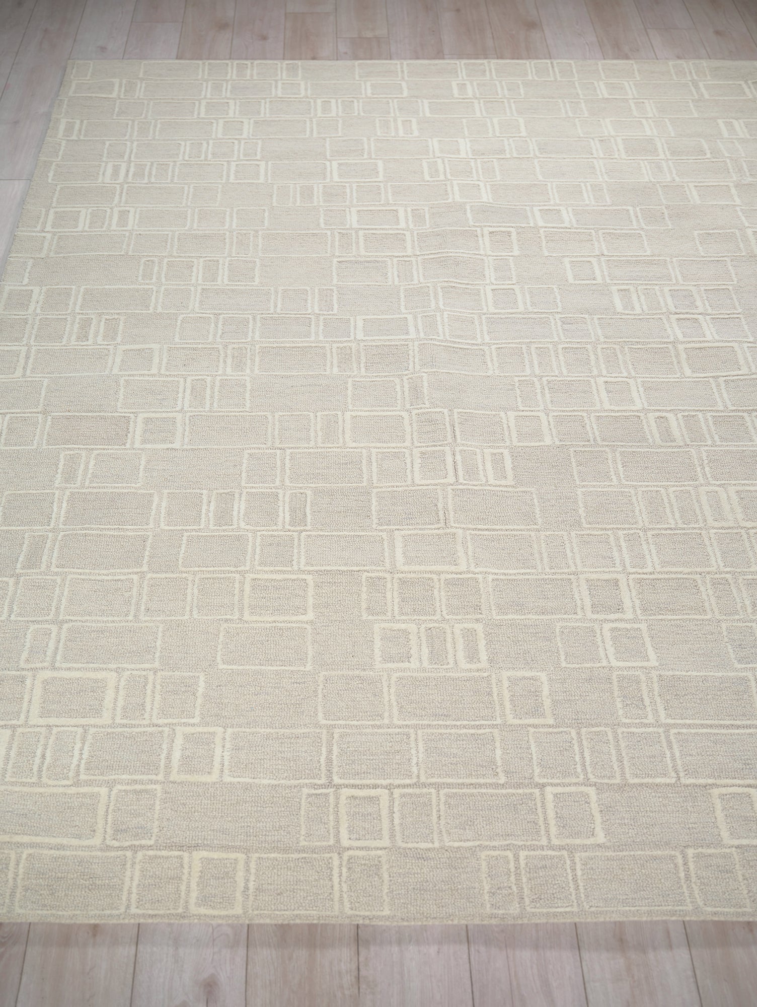 Cream rectangular rug with a modern geometric grid of square outlines in pale cream tones.