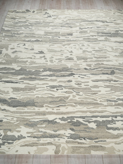 Abstract beige and gray rug with cream and taupe wave pattern on light wood floor.
