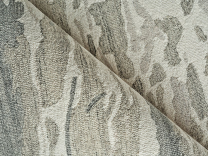 Beige and gray damask-patterned plush rug fabric, dense loop pile with abstract swirls, folded for display.