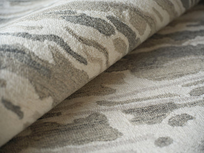 Beige and gray indoor hand-tufted rug with abstract marble-like pattern and soft, textured pile.