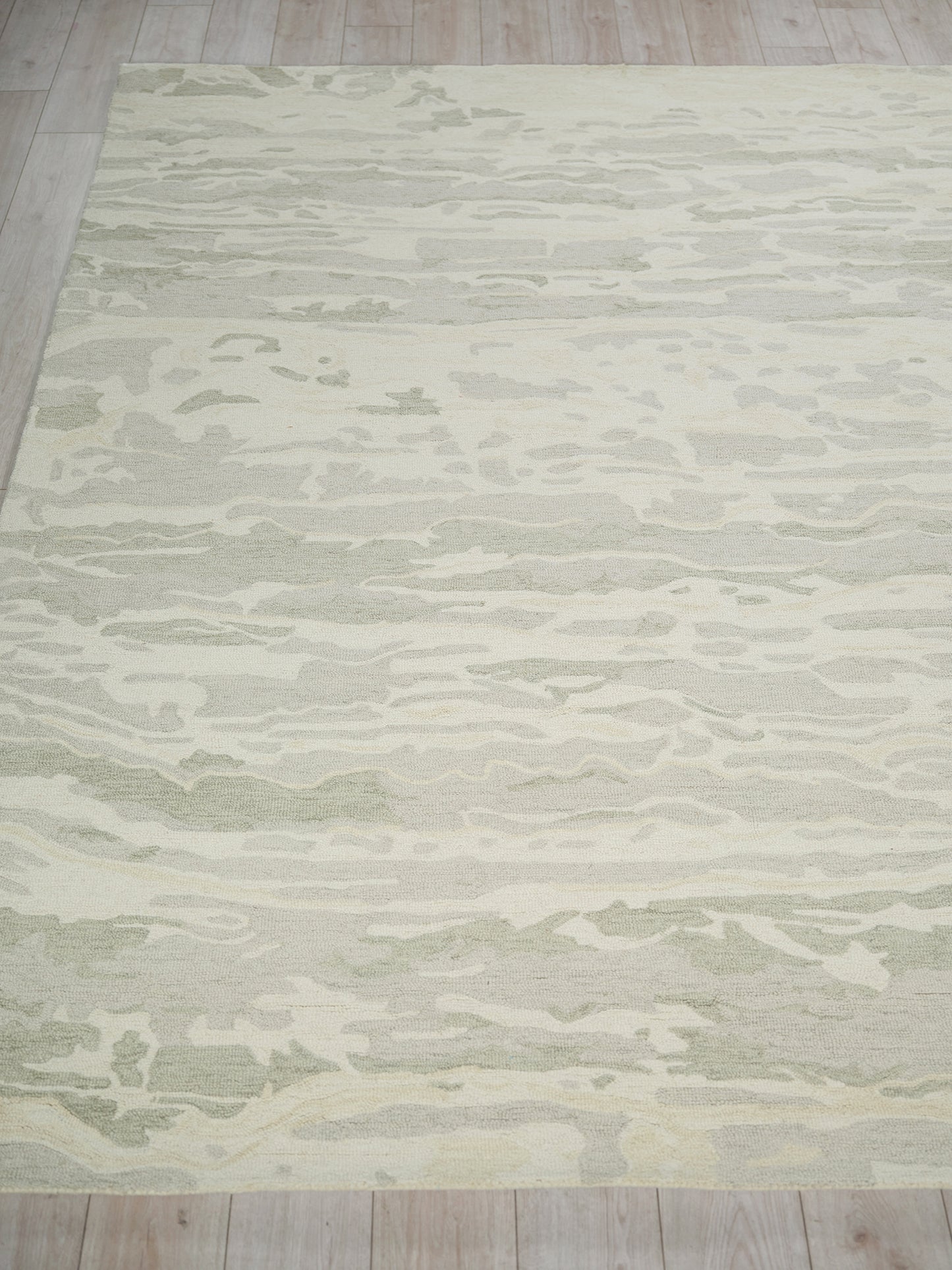 Gray and ivory abstract-pattern area rug on light wood floor.