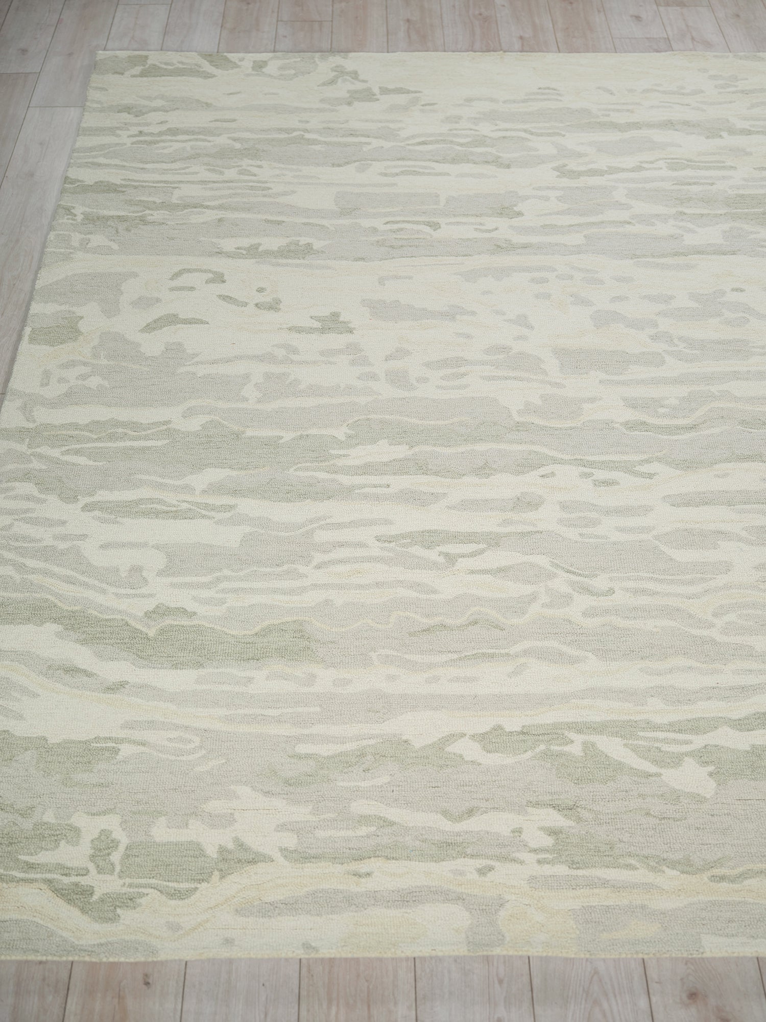 Gray and ivory abstract-pattern area rug on light wood floor.