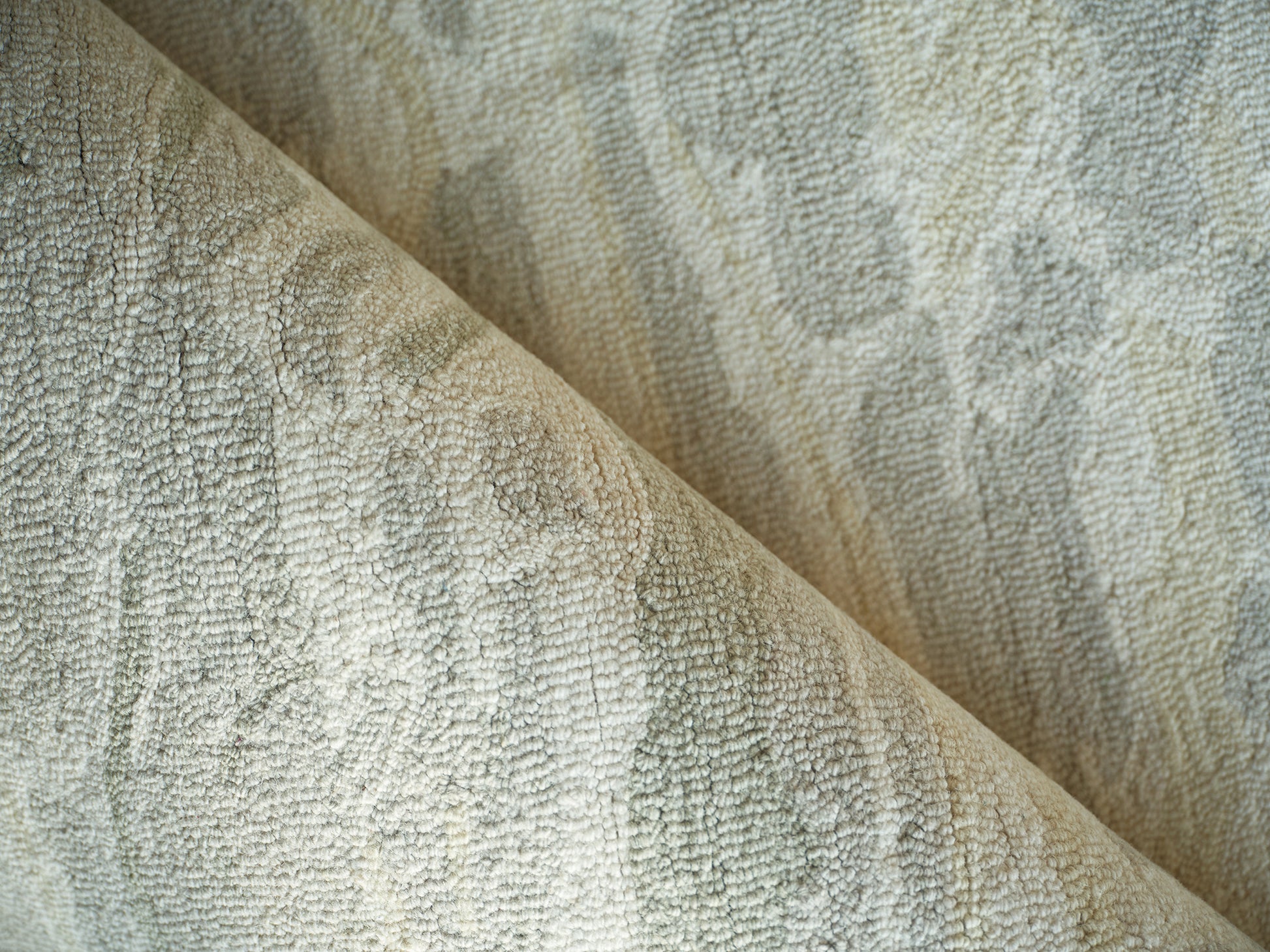 Beige-green textured boucle rug close-up with plush looped pile.