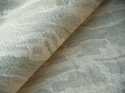 Beige and gray damask-pattern hand tufted rug with soft textured pile, rolled corner.