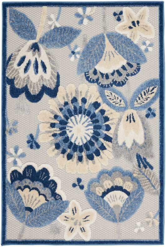 Floral area rug with blue & ivory blossoms, beige accents on light gray, navy border.