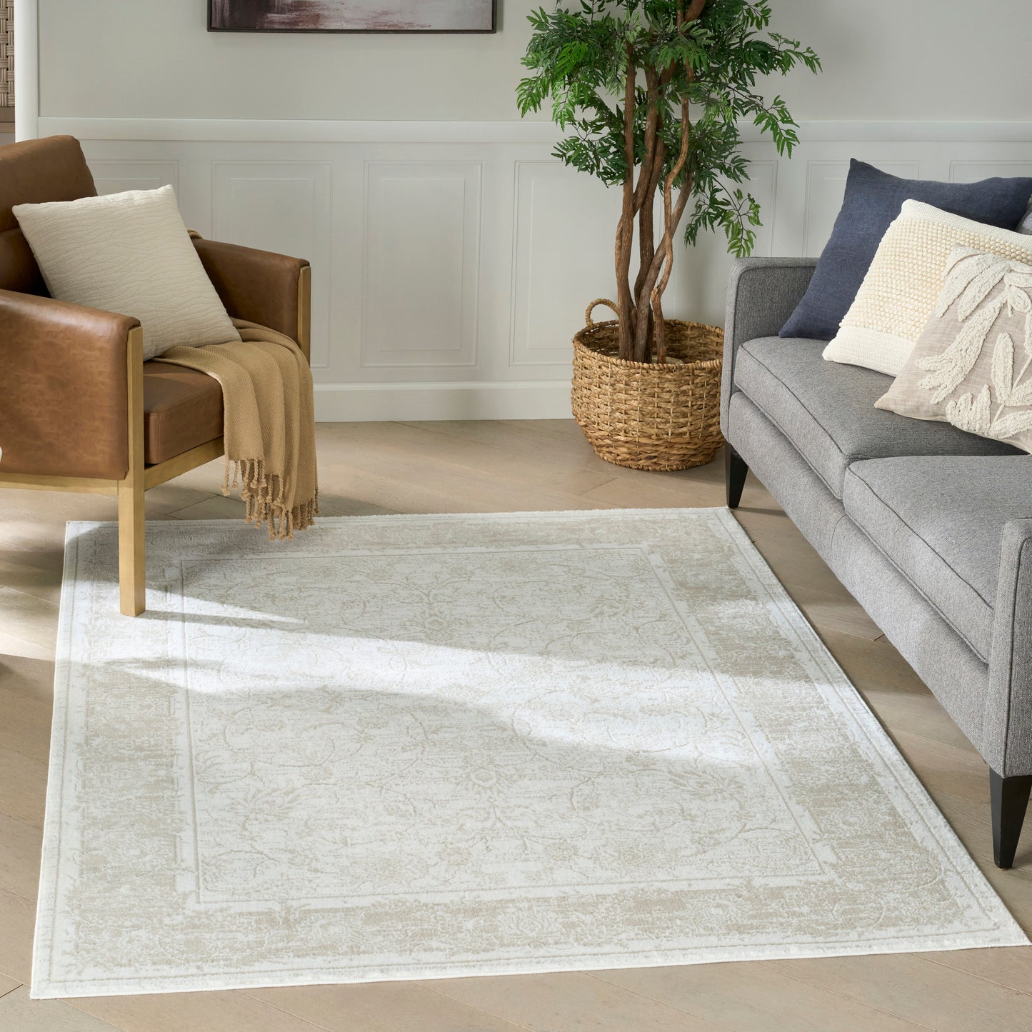 Neutral cream-beige woven area rug with subtle ornate border.