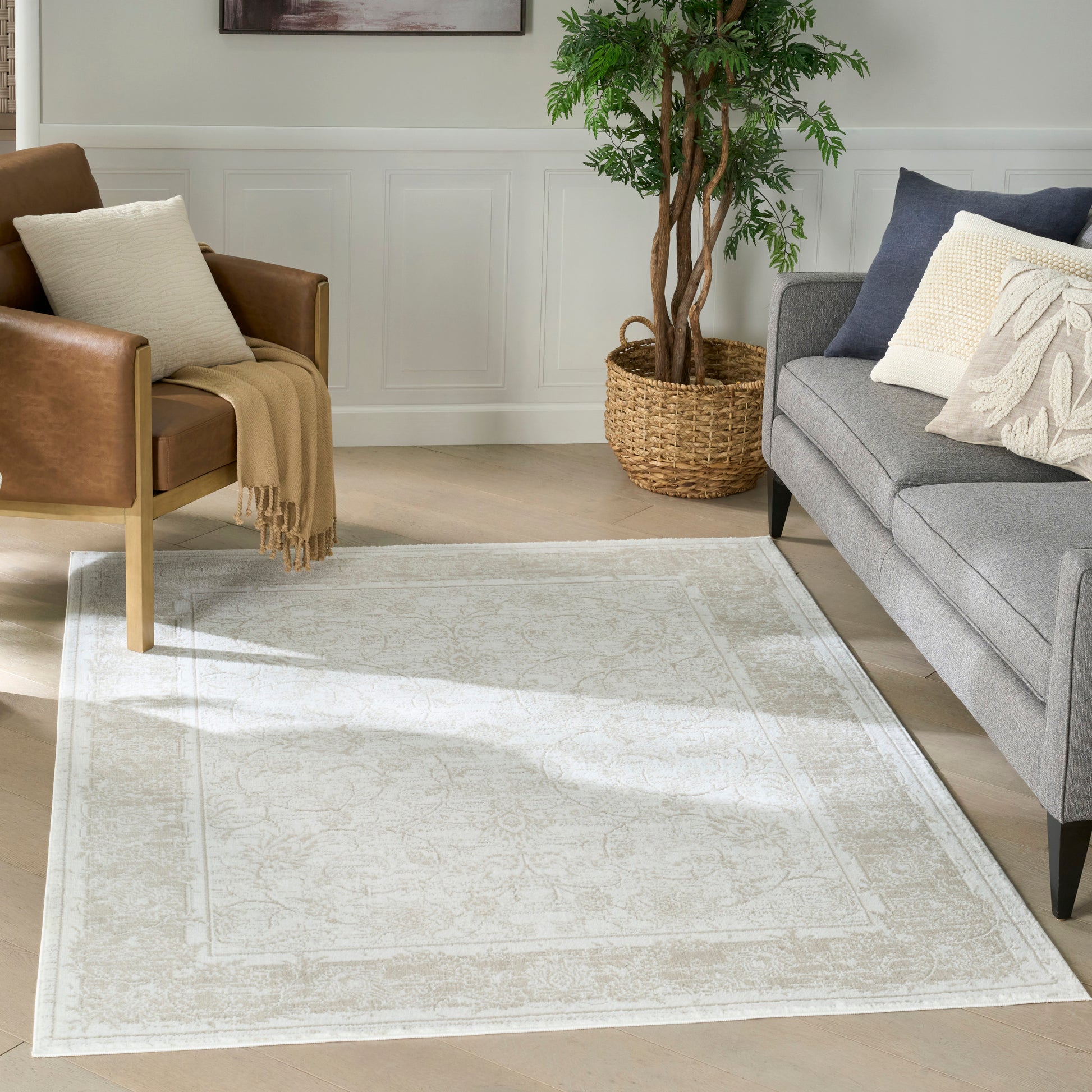 Neutral cream-beige woven area rug with subtle ornate border.