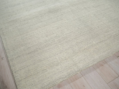 Beige indoor hand-tufted area rug, 2' x 3', textured with a subtle linear pattern on a light wood floor.