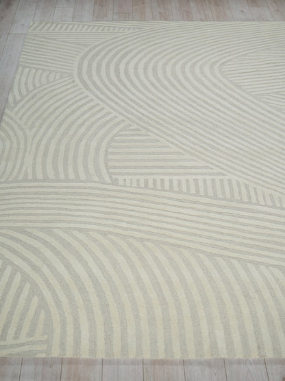Cream area rug with light beige wavy stripes forming an abstract geometric pattern.