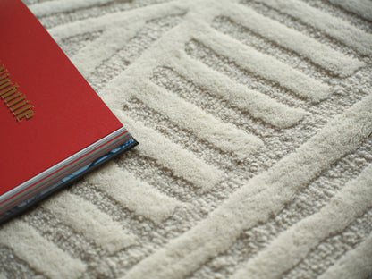 Beige textured rug with a geometric pattern.