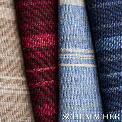Rolled striped woven fabrics in indigo tones; textile swatches for upholstery or curtains.
