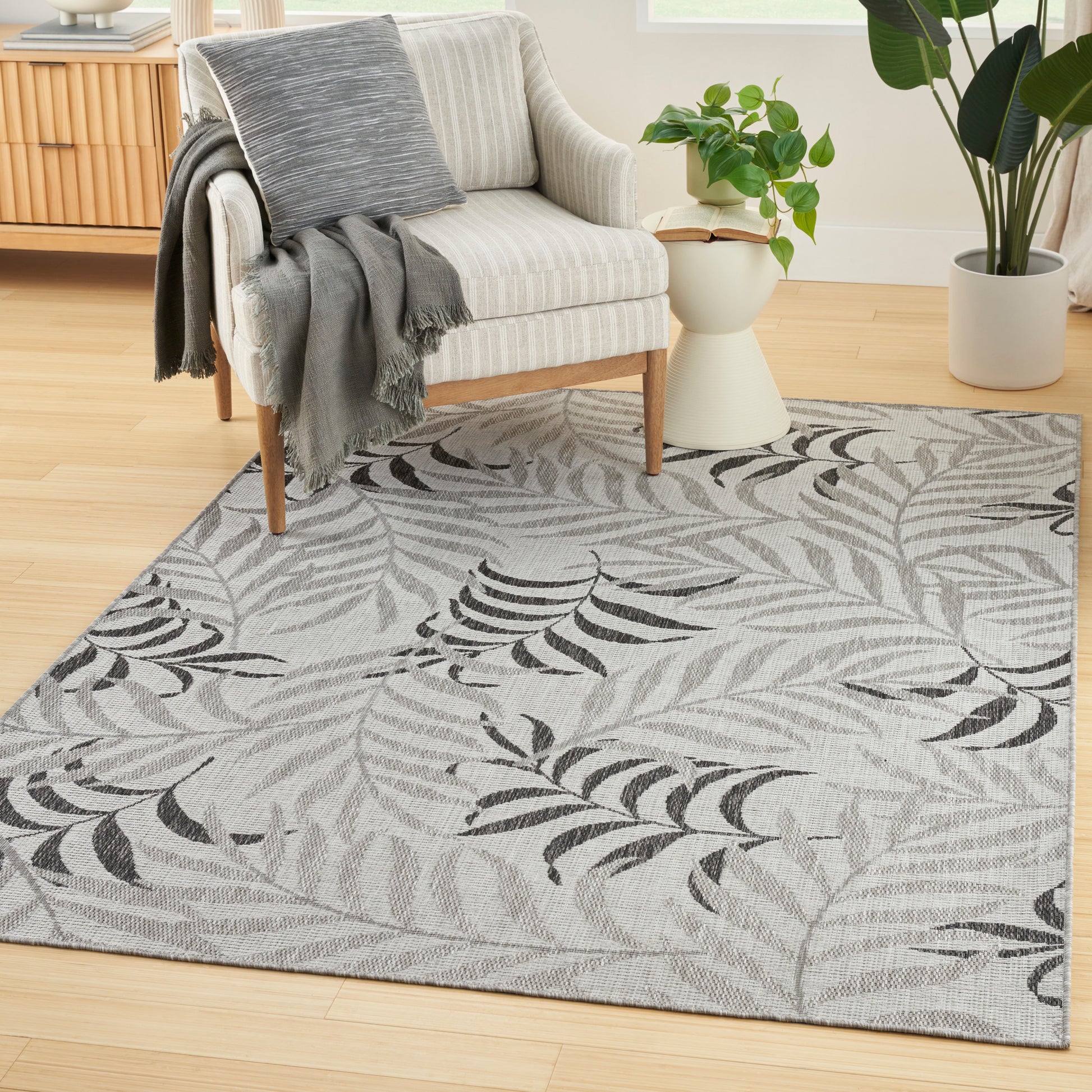 Tropical leaf-pattern rug on a bright living room floor, 6' x 9'.