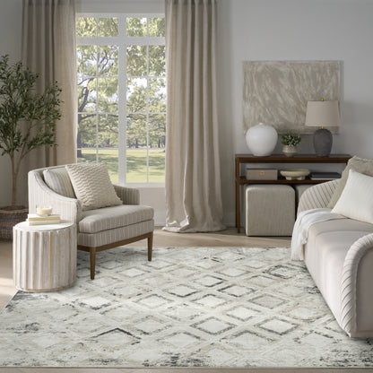 Neutral living room featuring beige sofa and armchair, diamond-pattern rug, cream curtains, wooden console and greenery.