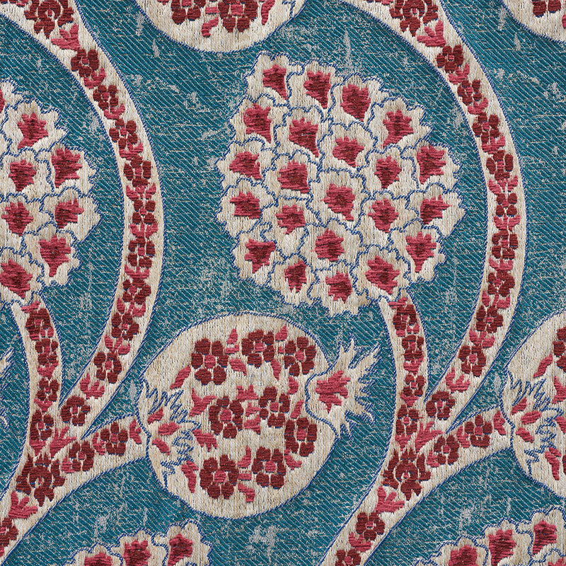 Teal woven textile with ivory floral medallions and red accents in an arabesque motif.