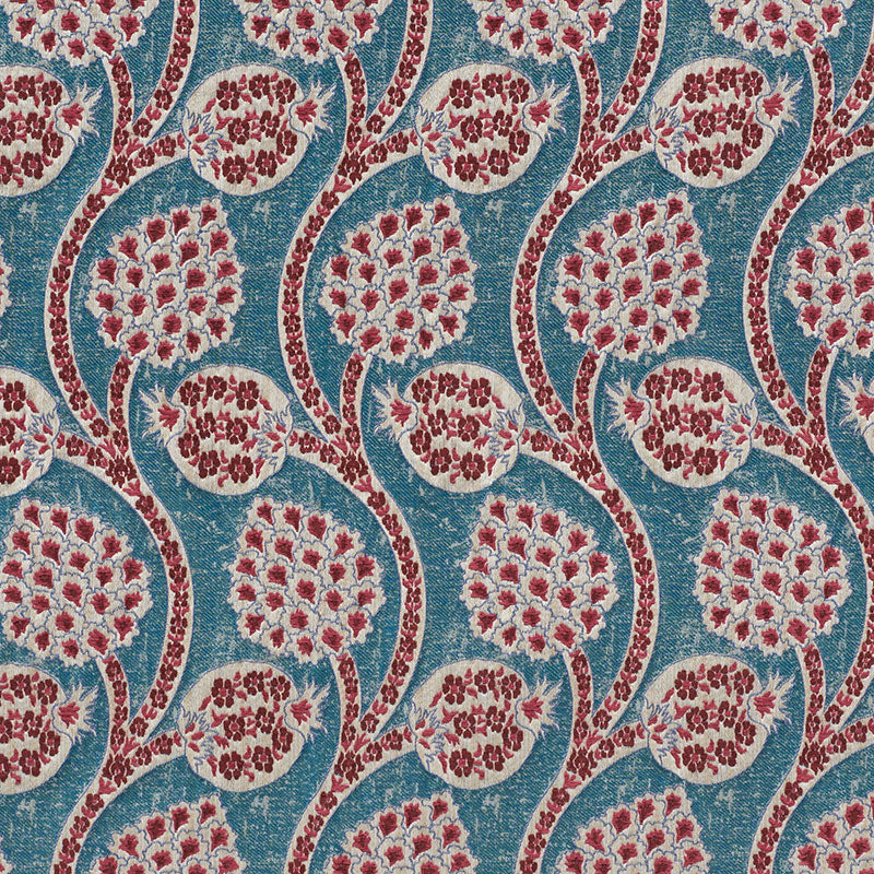 Blue fabric with red and white circular floral medallions linked by curved stems; boho textile for upholstery or curtains.
