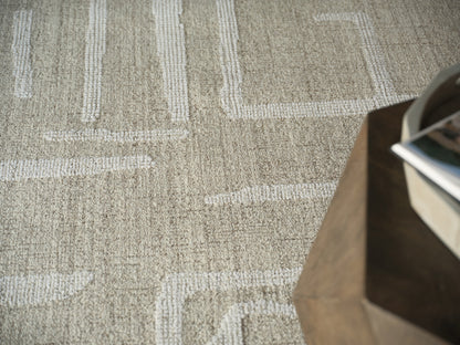 Beige textured rug with white geometric lines; dark wooden table edge on the right with magazines.