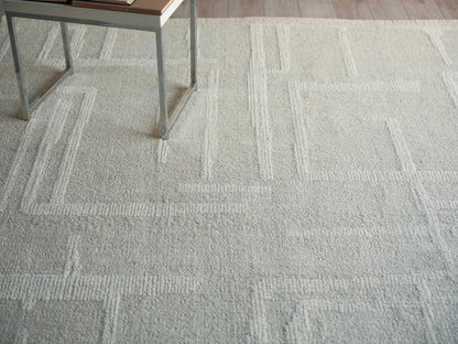Light gray textured area rug with a geometric rectangular border pattern.