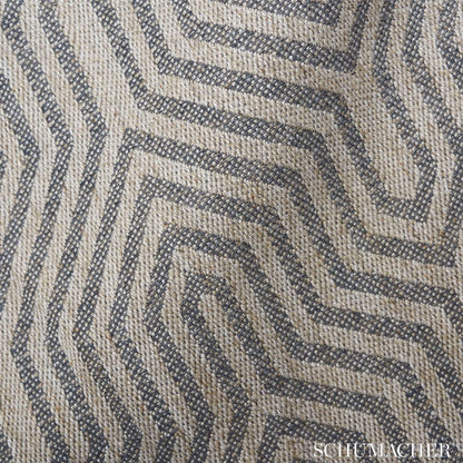 Beige and dark blue woven rug with a maze-like geometric pattern and textured surface.