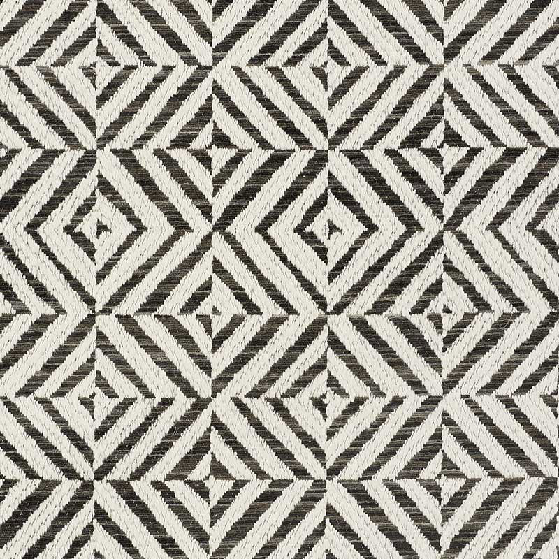 Black and white geometric rug with nested diamonds and chevron lines in a woven texture.