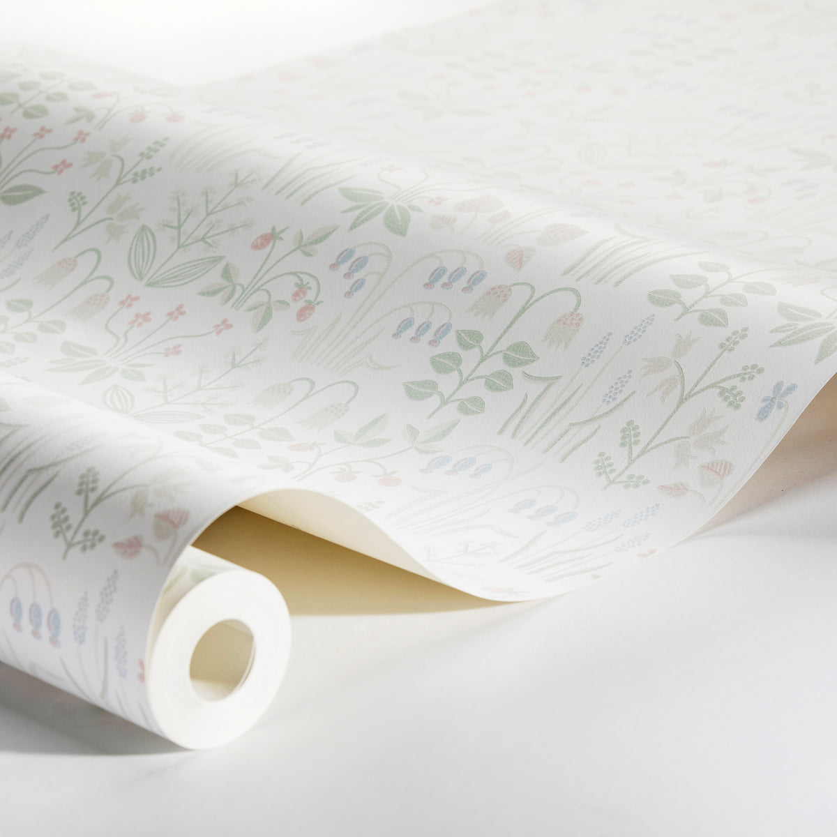 Rolled ivory wallpaper with a soft pastel botanical print of leaves and small blooms.