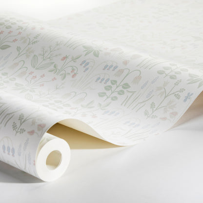 Rolled ivory wallpaper with a soft pastel botanical print of leaves and small blooms.