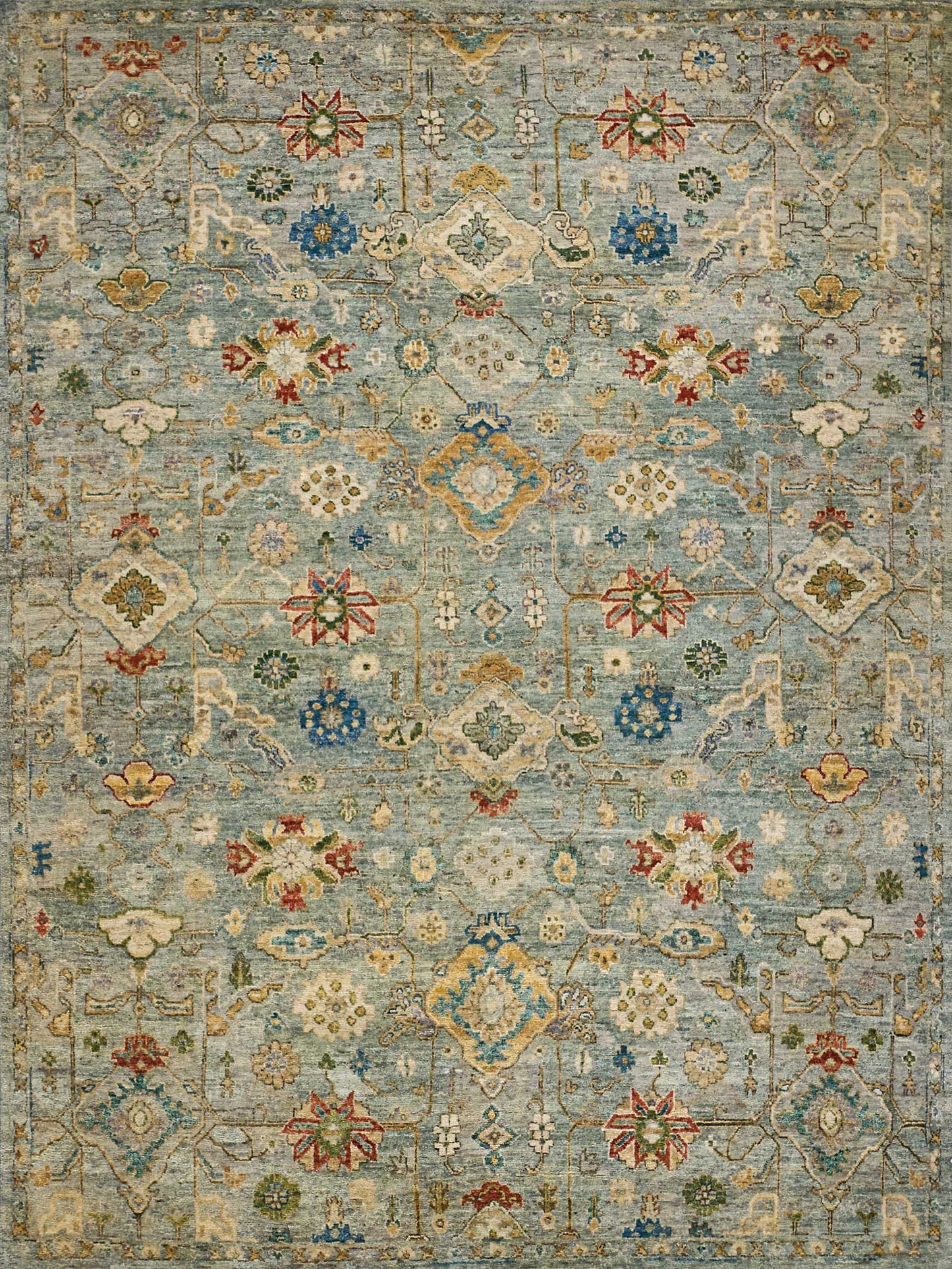 Blue oriental rug with floral medallions, ivory & gold accents, red & green details, intricate geometric lattice pattern.