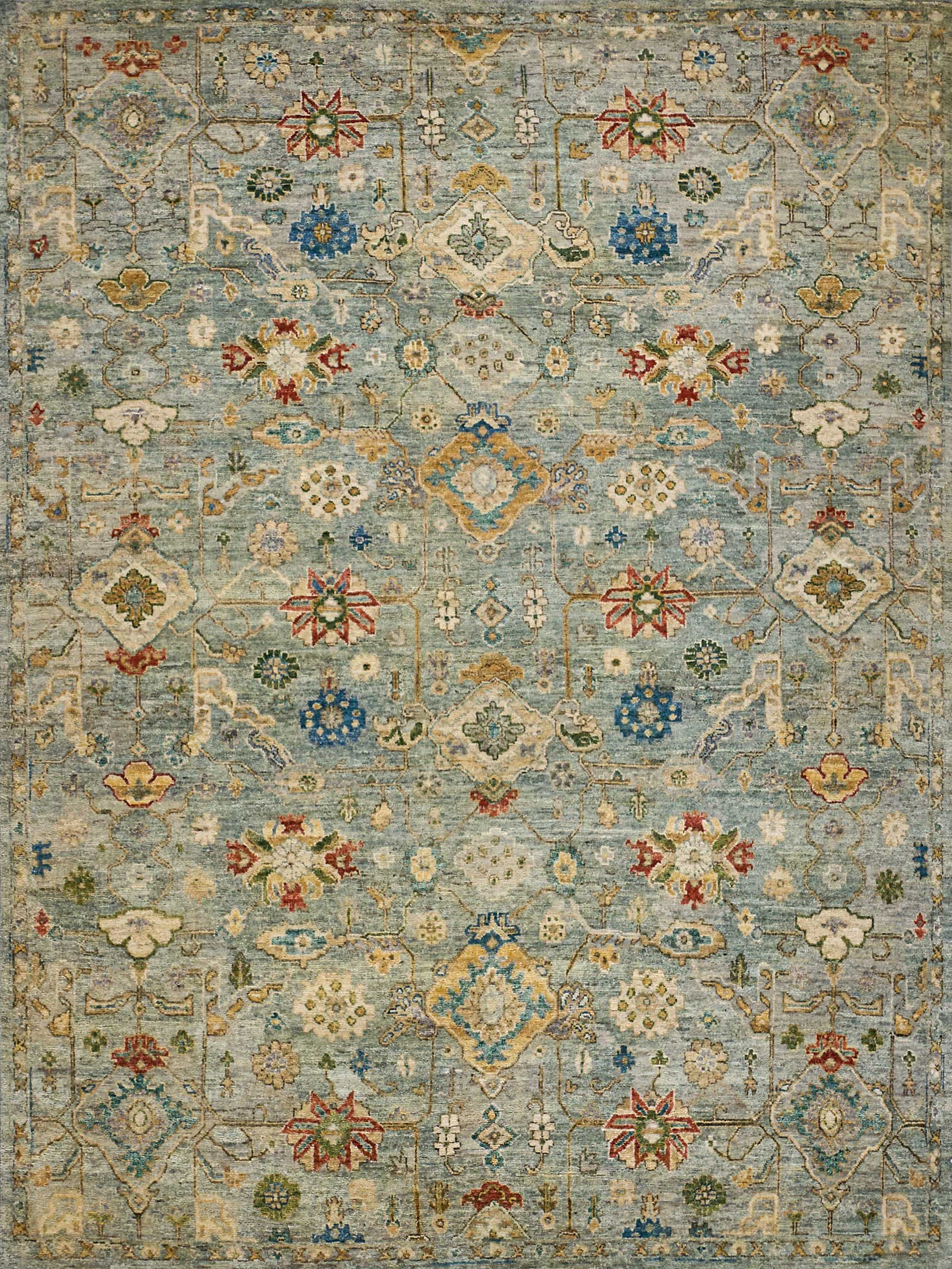 Blue oriental rug with floral medallions, ivory & gold accents, red & green details, intricate geometric lattice pattern.