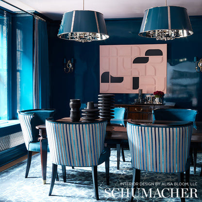 Teal-striped upholstered dining chairs around a dark wood table under teal pendant lamps; pink abstract wall art.