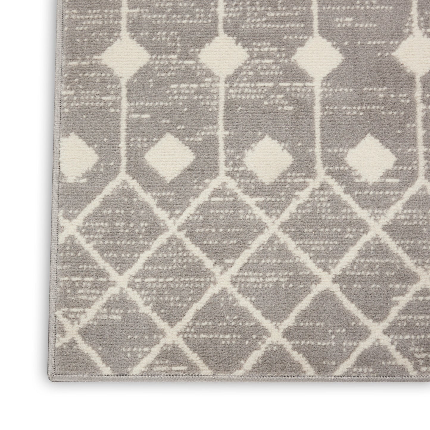 Taupe rug corner with cream lattice diamond trellis pattern; soft woven texture, modern Moroccan-inspired design.