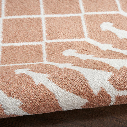 Close-up of a beige-pink rug with white geometric grid lines & abstract shapes; soft loop pile, modern style.