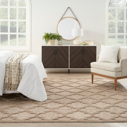 Bright bedroom with white bedding, beige knitted throw, dark chevron cabinet, round wood mirror, plant, lamp, beige rug.