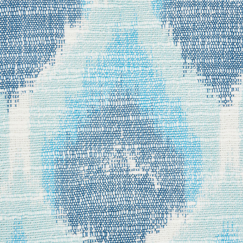 Blue and white woven rug with geometric diamond medallion pattern and textured weave.