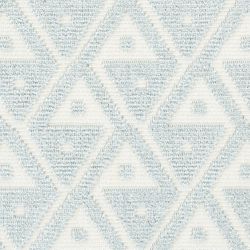 Soft blue and ivory geometric rug with diamond shapes and a woven textured surface.